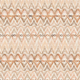 Detail of fabric in a painterly ikat print in shades of tan and orange on a white field.