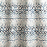 Draped fabric yardage in a painterly ikat print in shades of blue and navy on a white field.