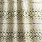 Draped fabric yardage in a painterly ikat print in shades of green on a white field.