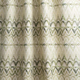 Draped fabric yardage in a painterly ikat print in shades of green on a white field.