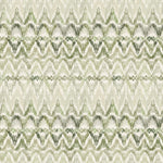 Detail of fabric in a painterly ikat print in shades of green on a white field.