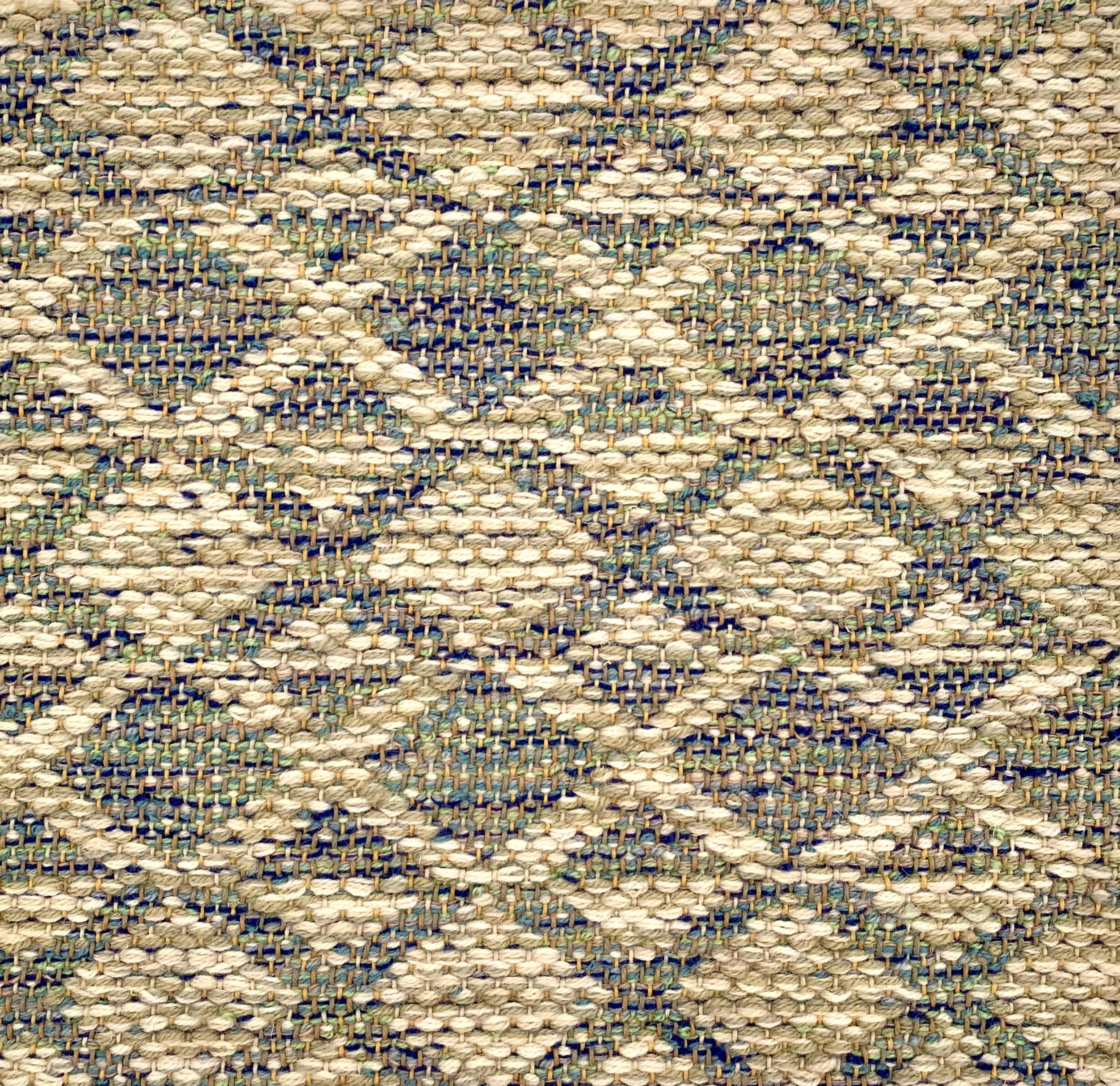 Handwoven rug detail in a lattice stripe design in blue, green, beige