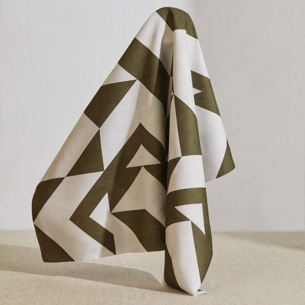 A large piece of draped fabric in a large-scale geometric print in brown on a white field.