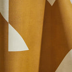 Draped wallpaper yardage in a large-scale geometric print in mustard on a cream field.