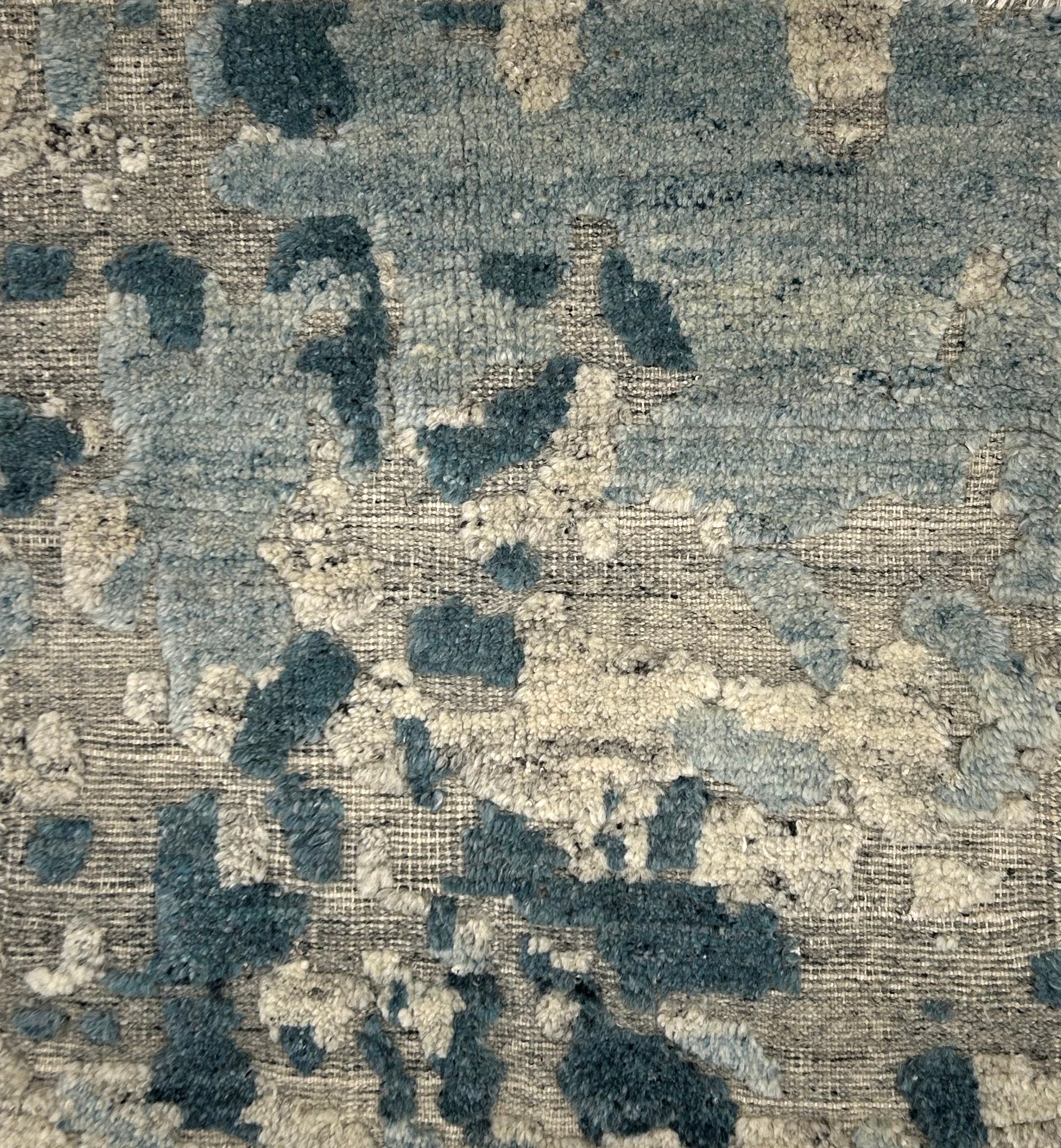 Handknotted rug in an abstract texture in shades of blue and grey. 