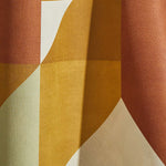 Draped wallpaper yardage in a large-scale geometric print in cream, mustard and rust.