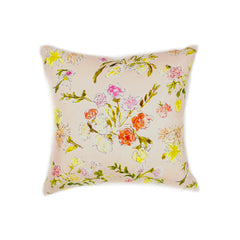 A throw pillow with a hand drawn brightly colored floral print on a light pink ground.