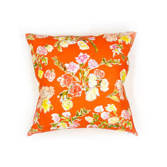 A throw pillow with a hand drawn brightly colored floral print on a red ground.