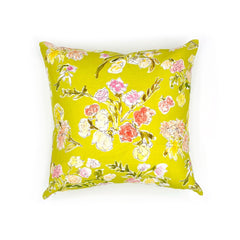A throw pillow with a hand drawn brightly colored floral print on a lime green  ground.