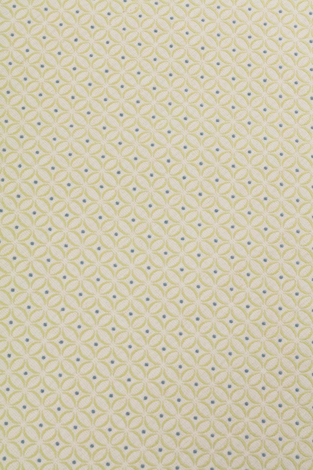 Detail of woven fabric in a geometric grid print in yellow and blue on a tan field.