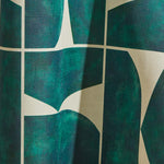 Draped wallpaper yardage in a geometric grid print in dark green on a mottled cream field.