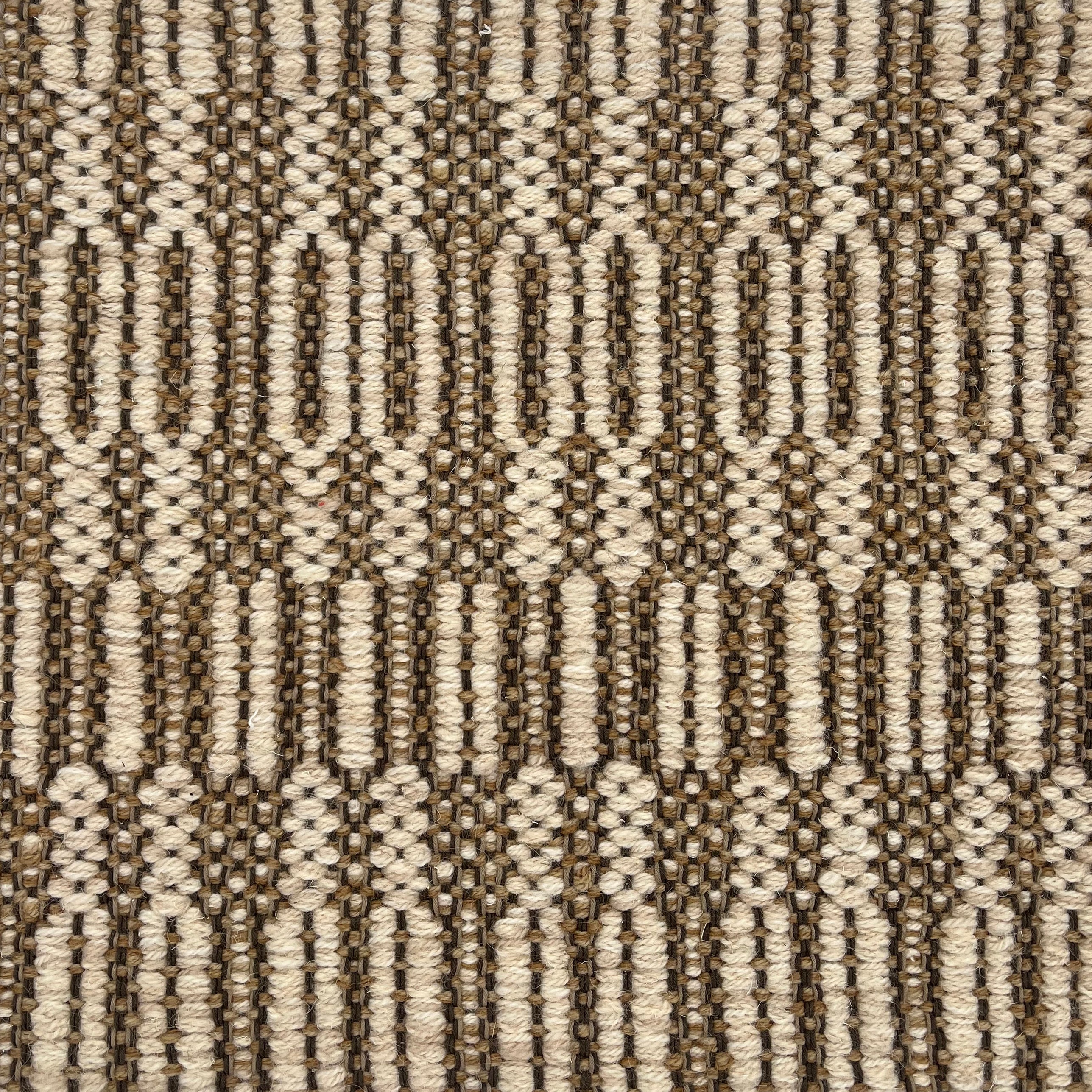 Handwoven rug detail in a geometric   design in tan and beige