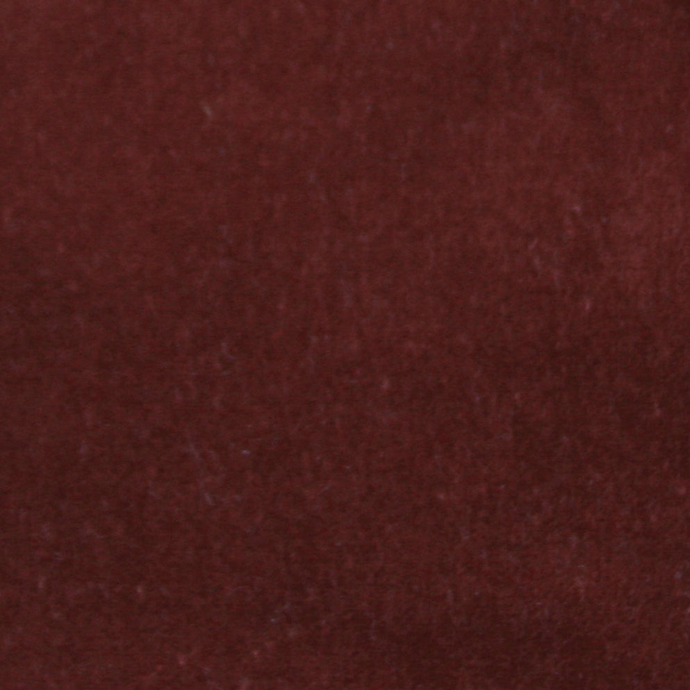 Detail of velvet fabric yardage in maroon.