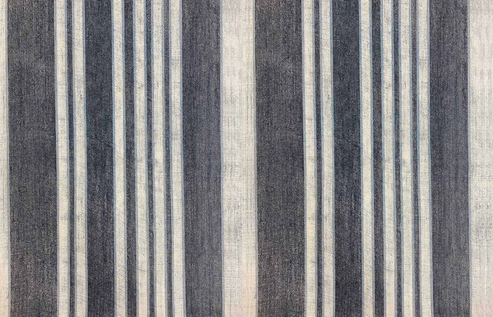 Detail of wallpaper in an irregular stripe print in shades of cream, blue and gray.