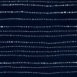 Detail of cotton fabric in a broken stripe pattern in white on an indigo field.