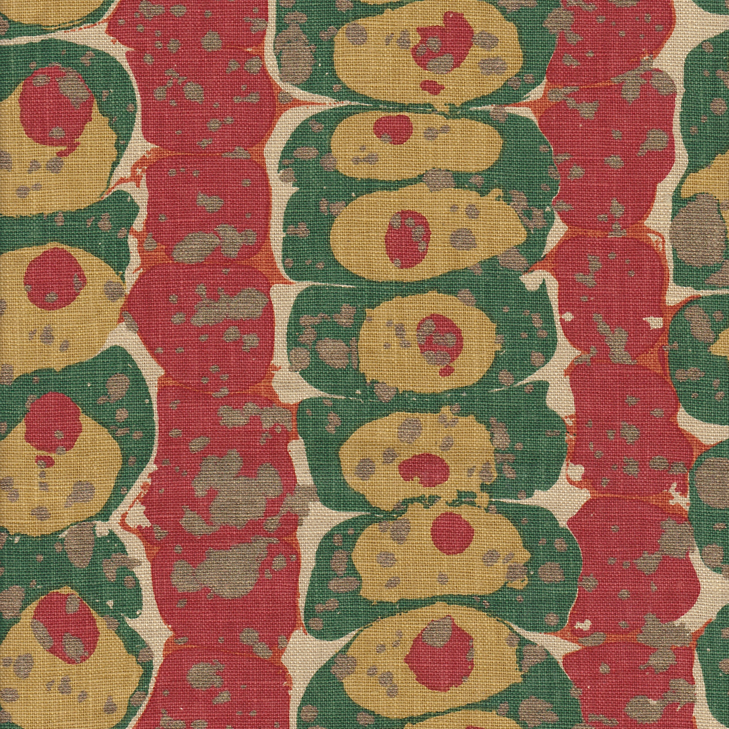 Detail of fabric in a marbled paint print in shades of red, green and gold.