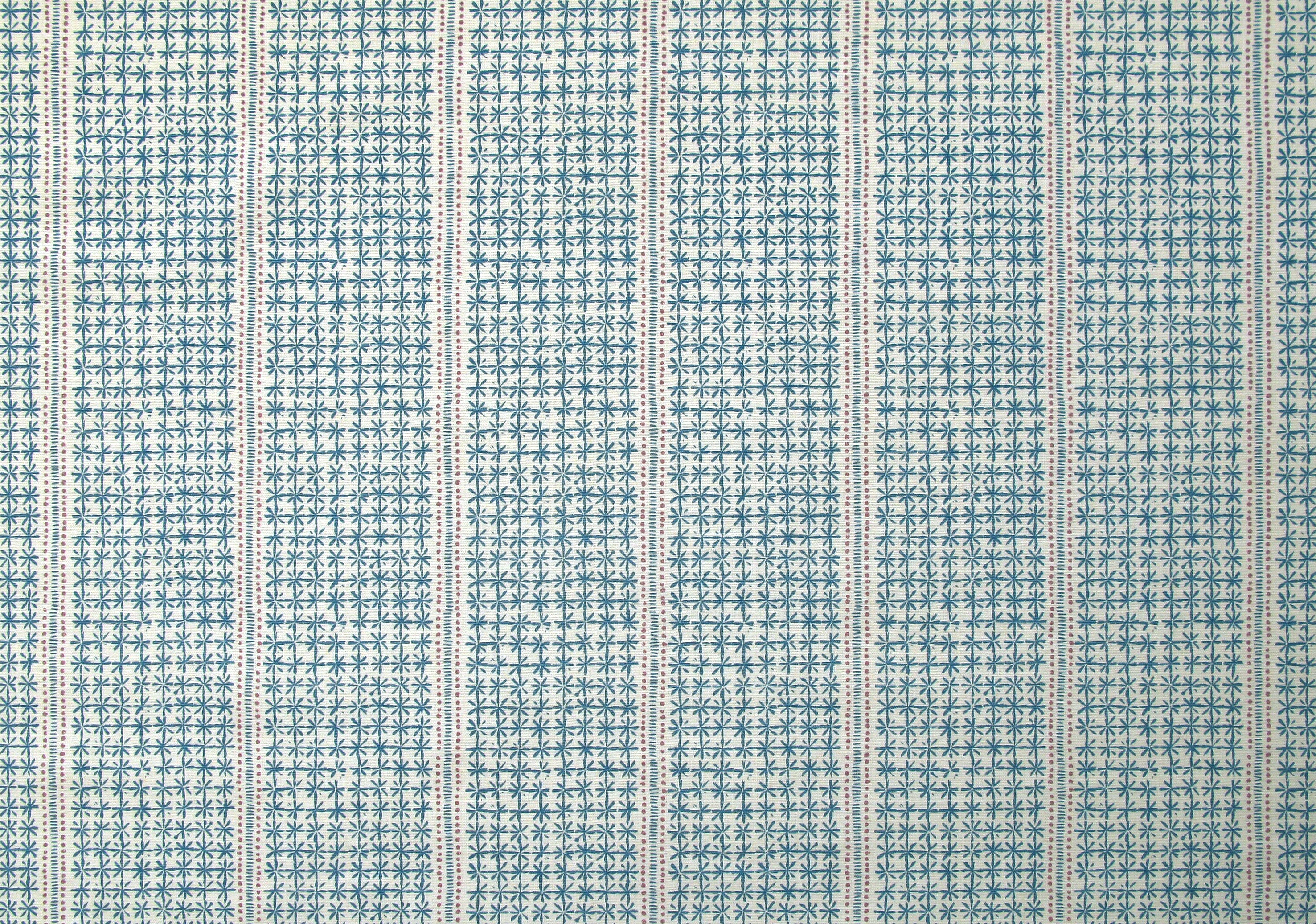 Detail of fabric in a dense repeating stripe and star print in blue on a cream field.