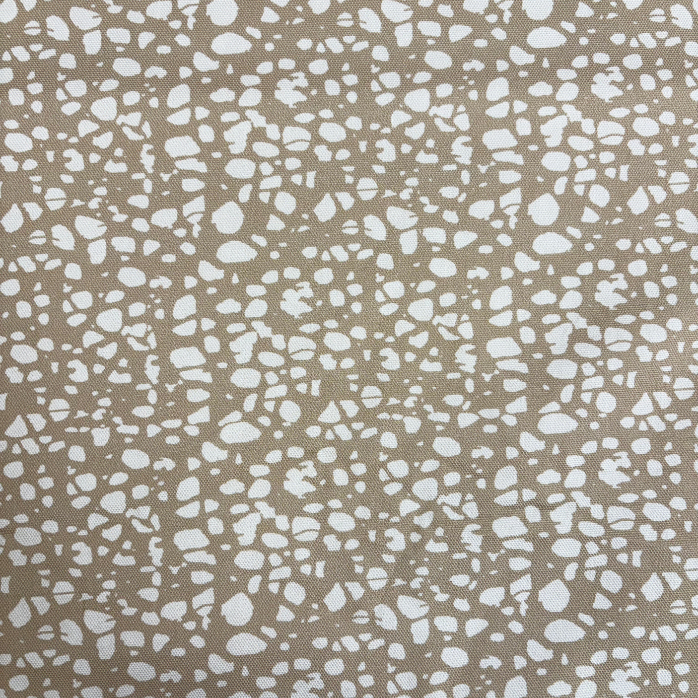 Patterned fabric with white speckles on a beige background