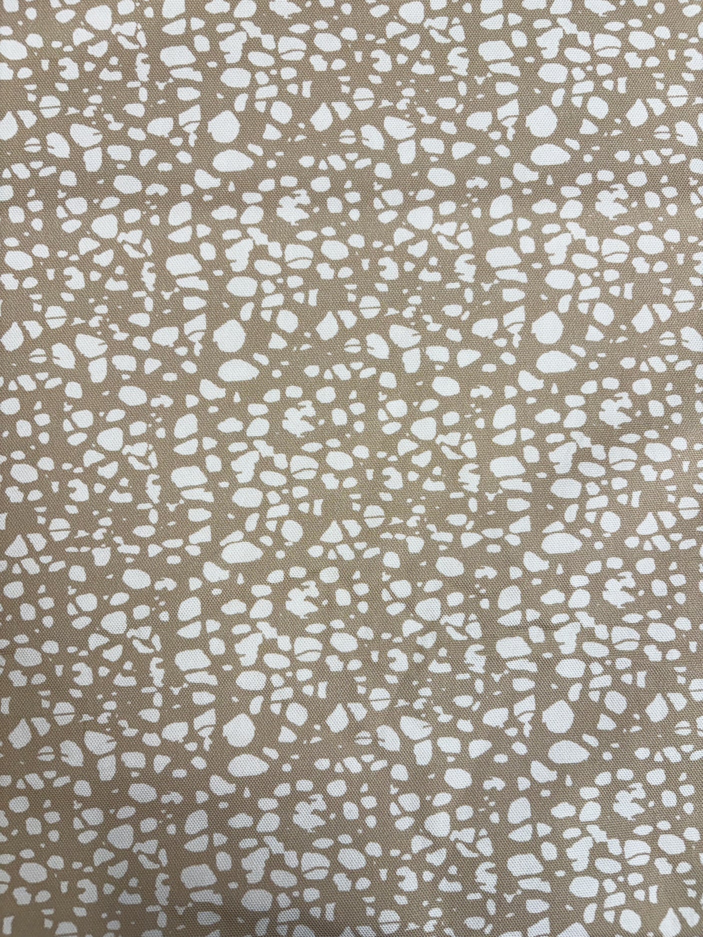 Patterned fabric with white speckles on a beige background