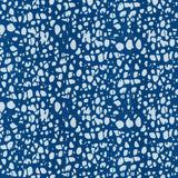 Detail of fabric in a batik splatter print in light blue on a navy field.