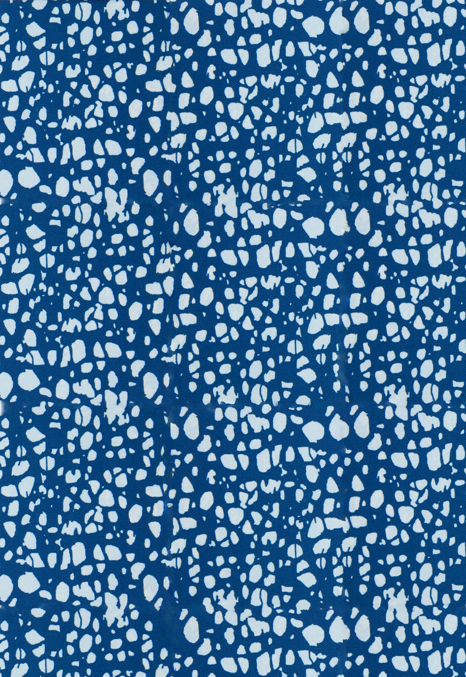 Detail of fabric in a batik splatter print in light blue on a navy field.