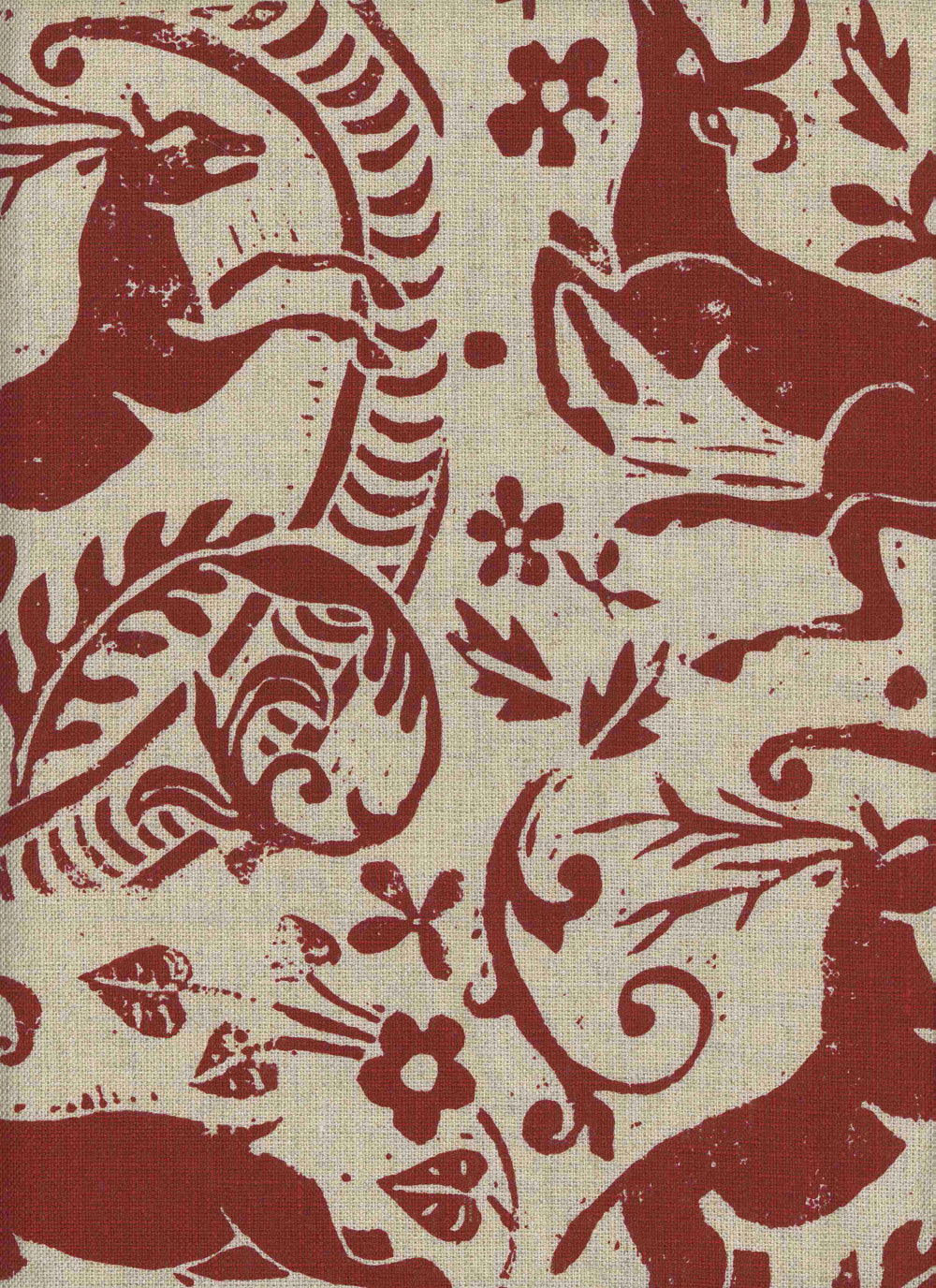 Close-up of fabric in a deer, leaf and flower print in red on a tan field.