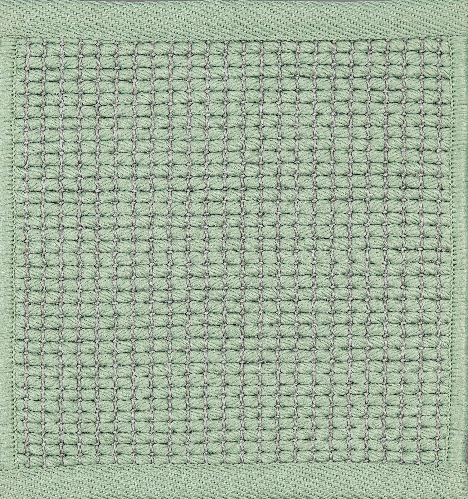 Textured woven outdoor carpet in sea foam green.
