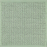 Textured woven outdoor carpet in sea foam green.