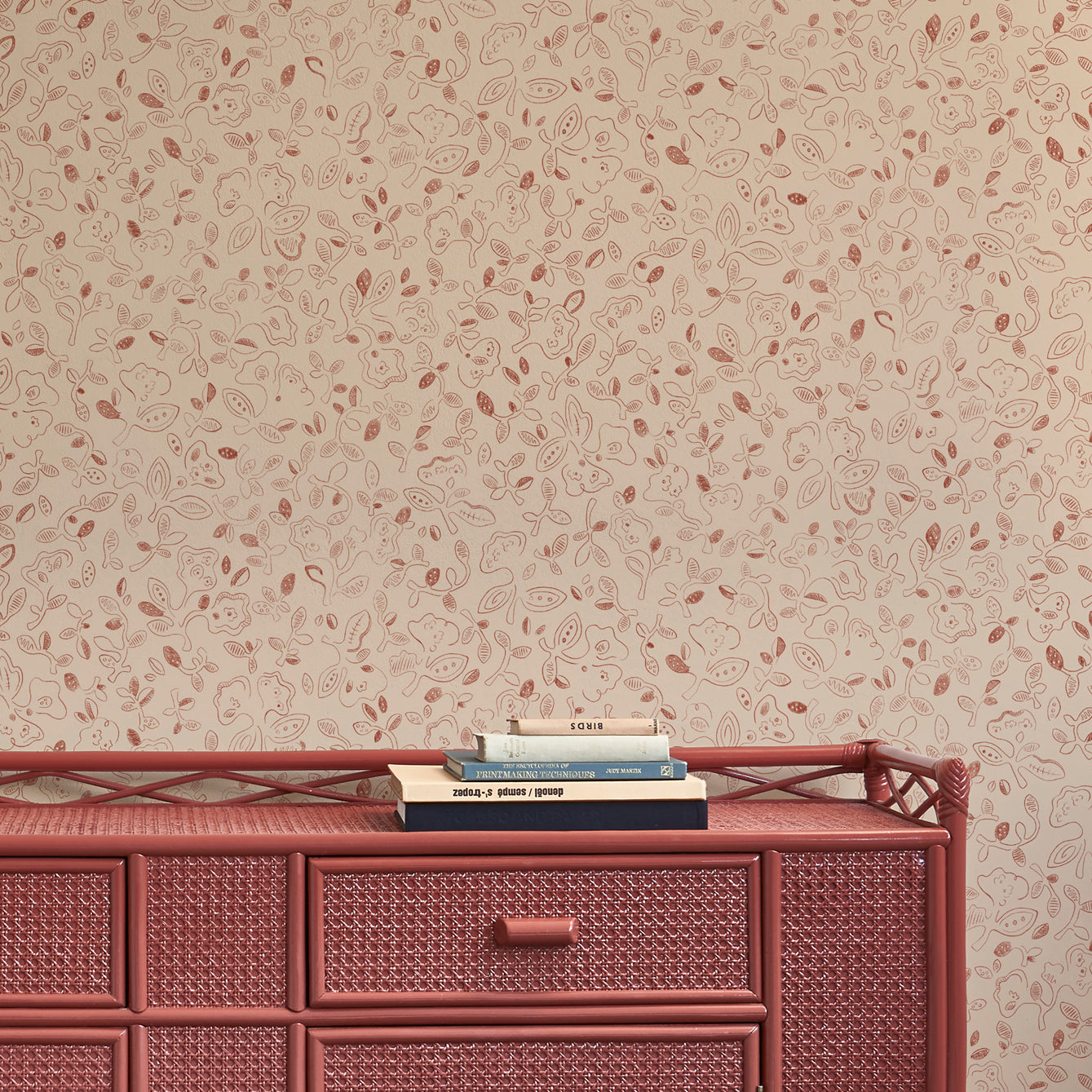 Woven red sideboard against a hand drawn floral patterned beige wall