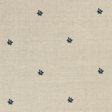 Detail of a printed linen fabric in a repeating small-scale flower pattern in navy on a cream field.