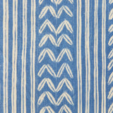 Detail of fabric in a painterly stripe and chevron print in blue on a cream field.