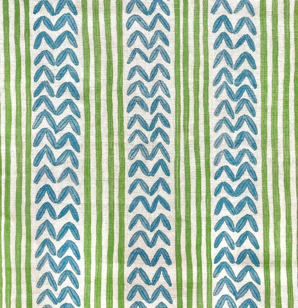 Detail of fabric in a painterly stripe and chevron print in blue and green on a white field.