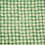 Detail of fabric in a circular floral print in light green and white on a mottled green field.