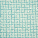 Detail of fabric in a circular floral print in turquoise and white on a blue field.