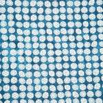 Detail of fabric in a circular floral print in light blue and white on a mottled blue field.