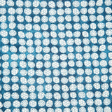 Detail of fabric in a circular floral print in light blue and white on a mottled blue field.