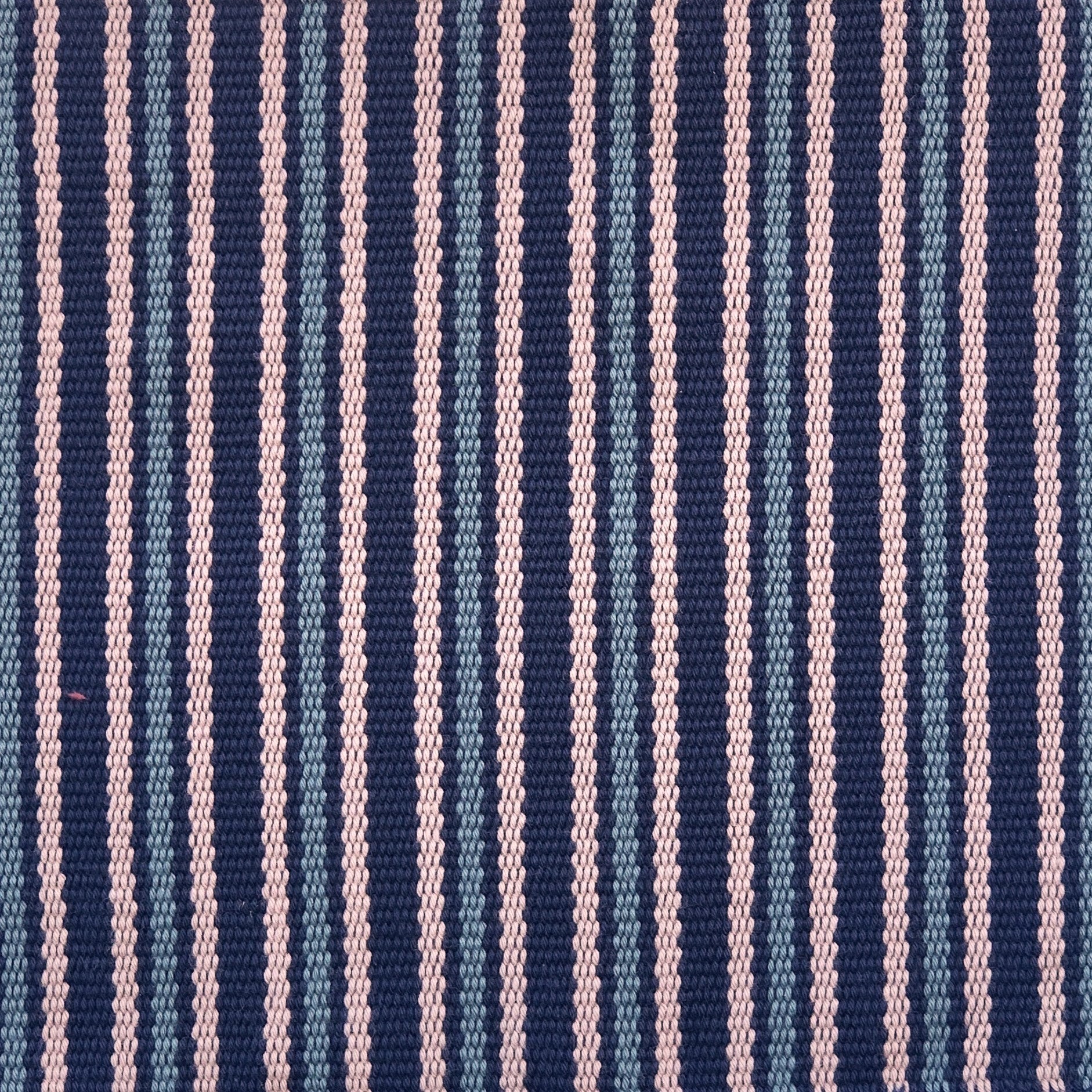 Detail of a hand-woven cotton fabric in a stripe pattern in shades of purple, pink and blue.