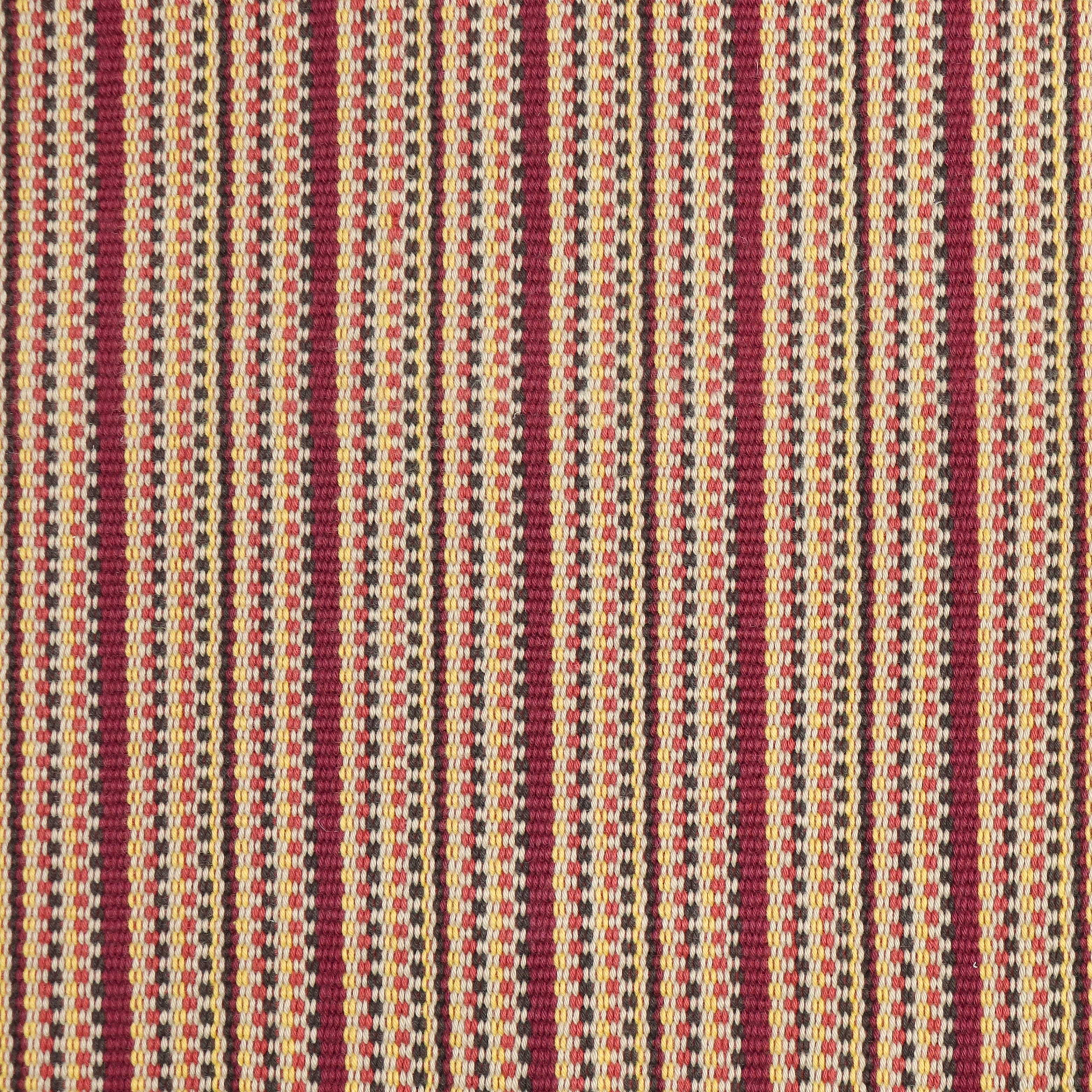 Detail of a hand-woven cotton fabric in an intricate gridded stripe pattern in shades of red, brown, yellow and cream.