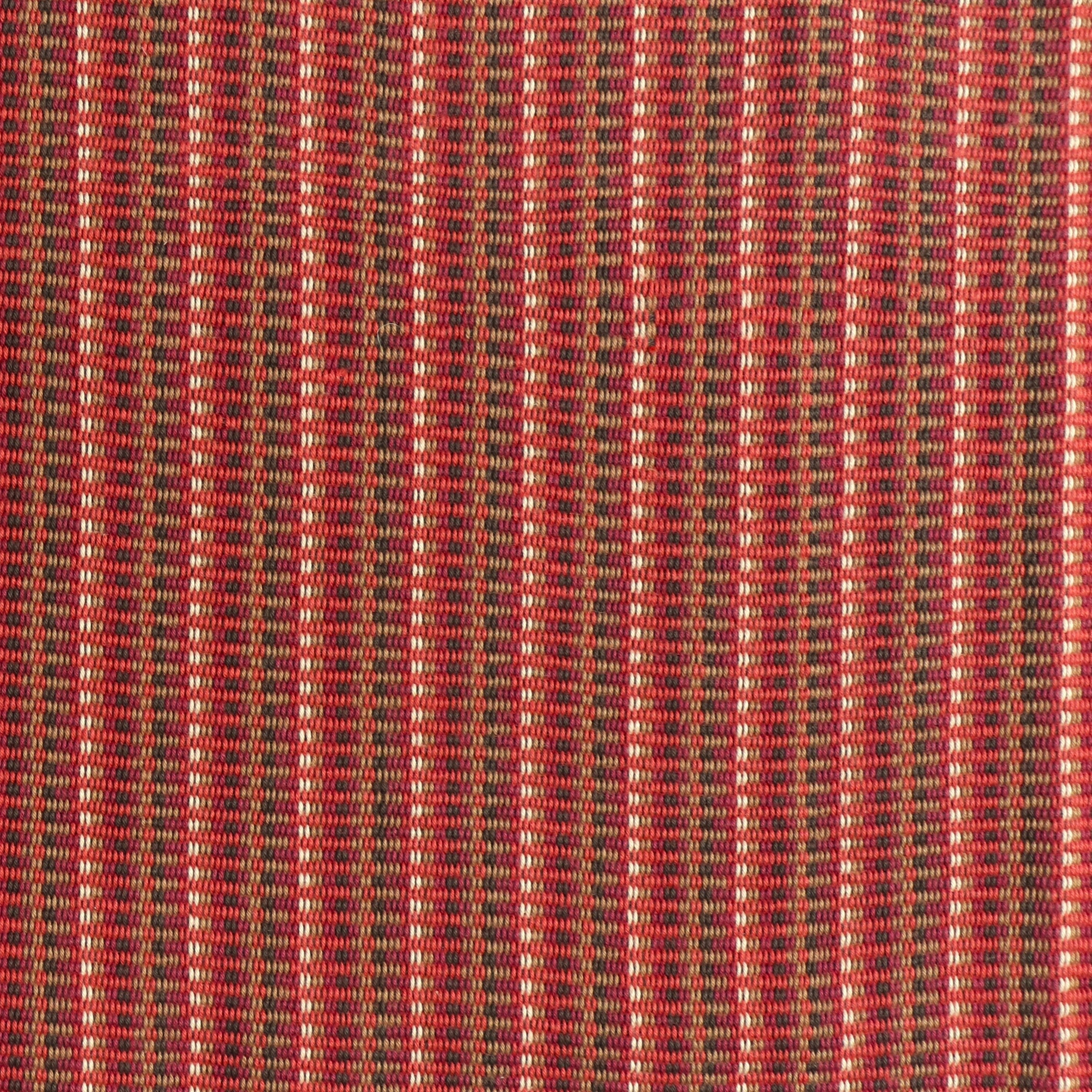 Detail of a hand-woven cotton fabric in an intricate stripe pattern in shades of red, maroon, navy and tan.