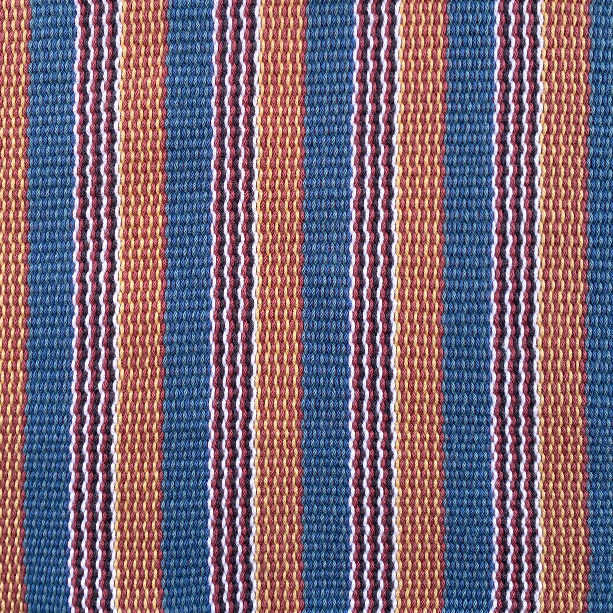 Detail of a hand-woven cotton fabric in a stripe pattern in shades of blue, pink, yellow and teal.