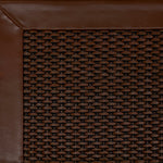 Close-up of woven leather rug with a wide leather binding in warm brown.
