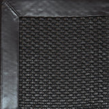 Close-up of woven leather rug with a wide leather binding in dark brown.