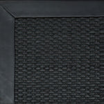 Close-up of woven leather rug with a wide leather binding in black.