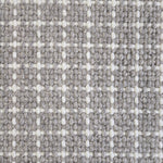 Close-up of a carpet with a textured check pattern in grey and white.