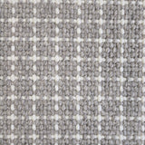 Close-up of a carpet with a textured check pattern in grey and white.
