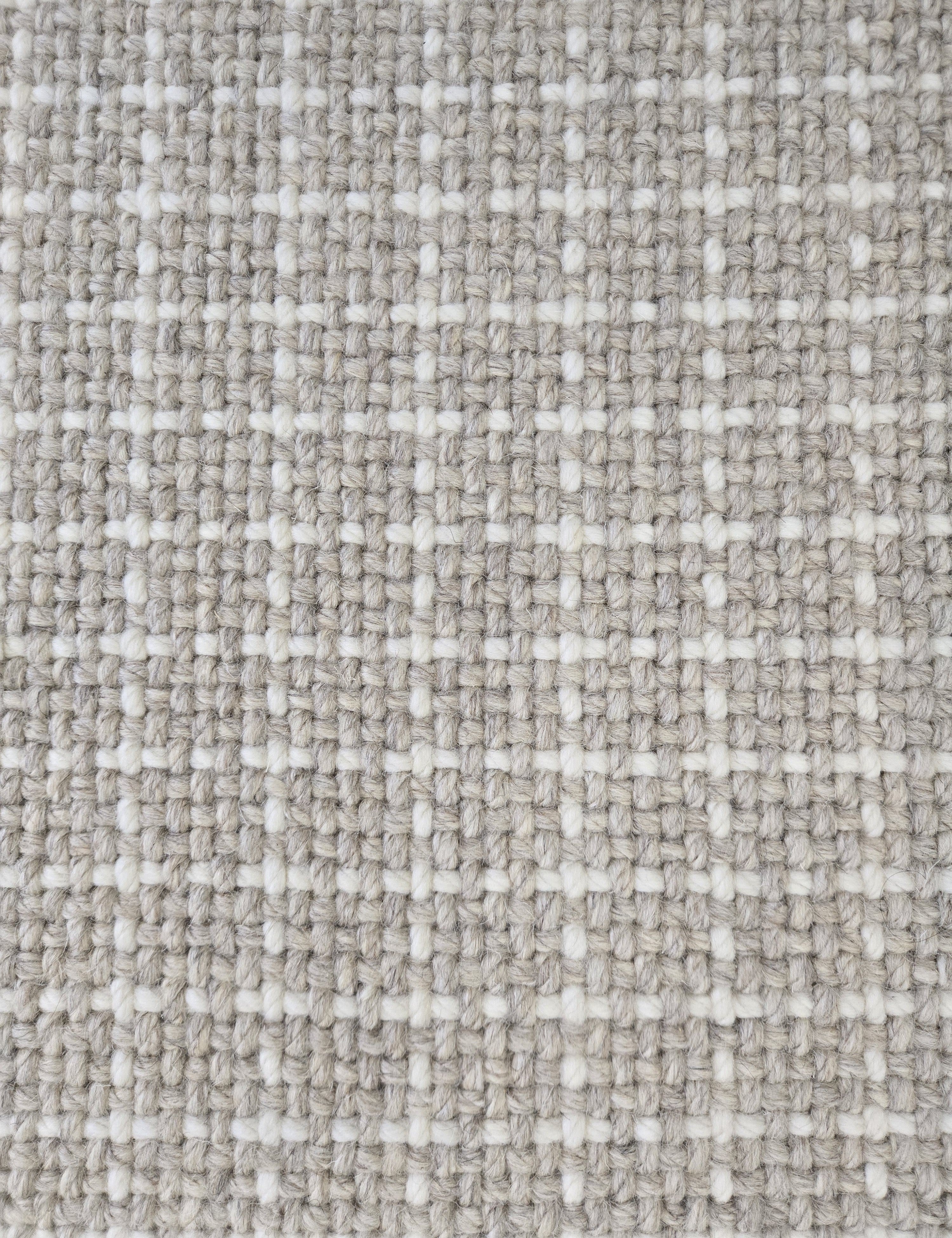 Close-up of a carpet with a textured check pattern in grey and white.