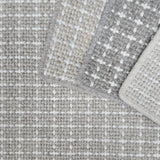 Close-up of check patterned carpet samples in neutral colors. 