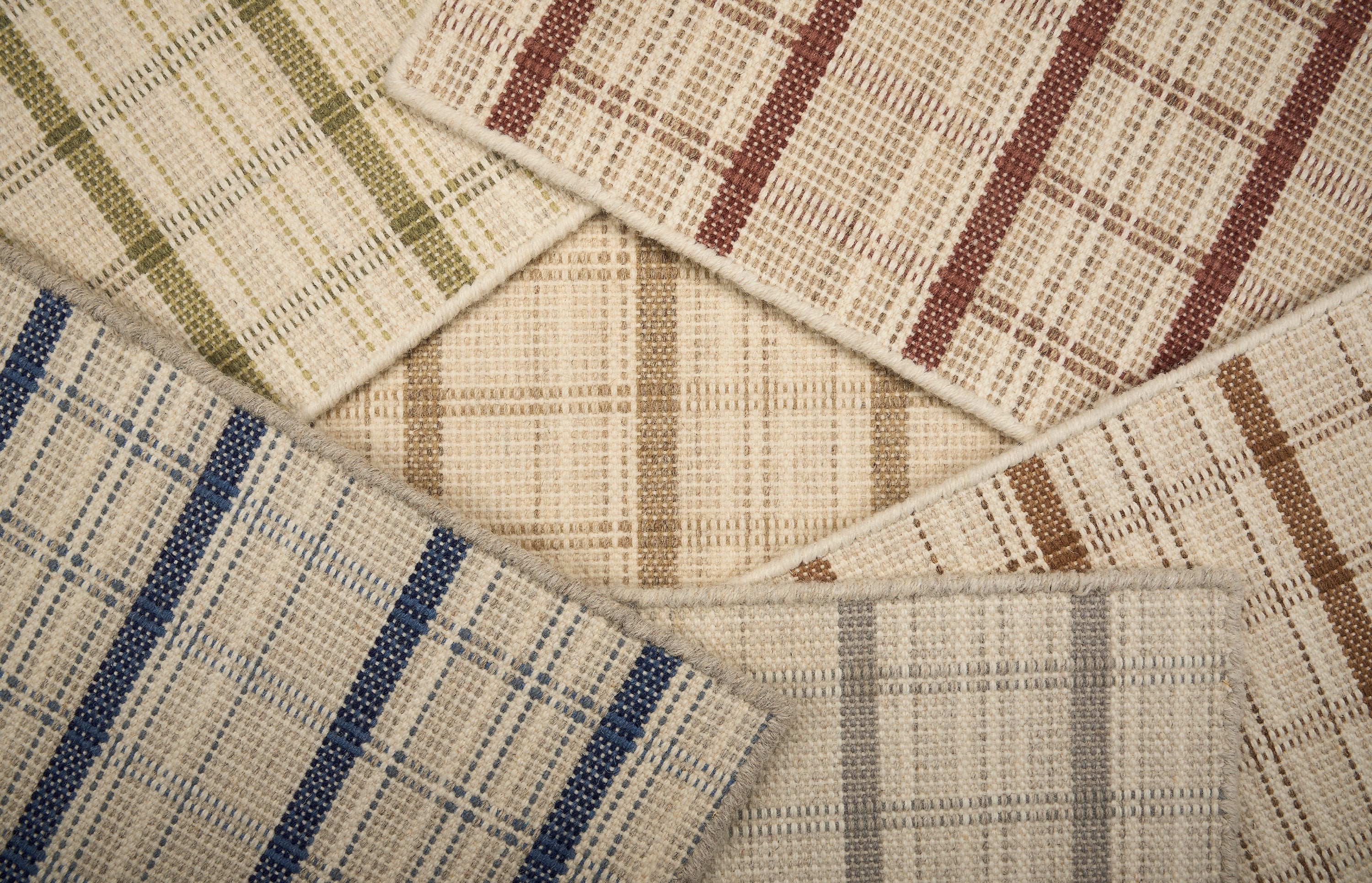 Scattered broadloom samples in windowpane plaid pattern in array of colors. 