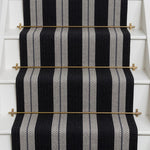 Striped brown flatweave runner in black and white on white stairs