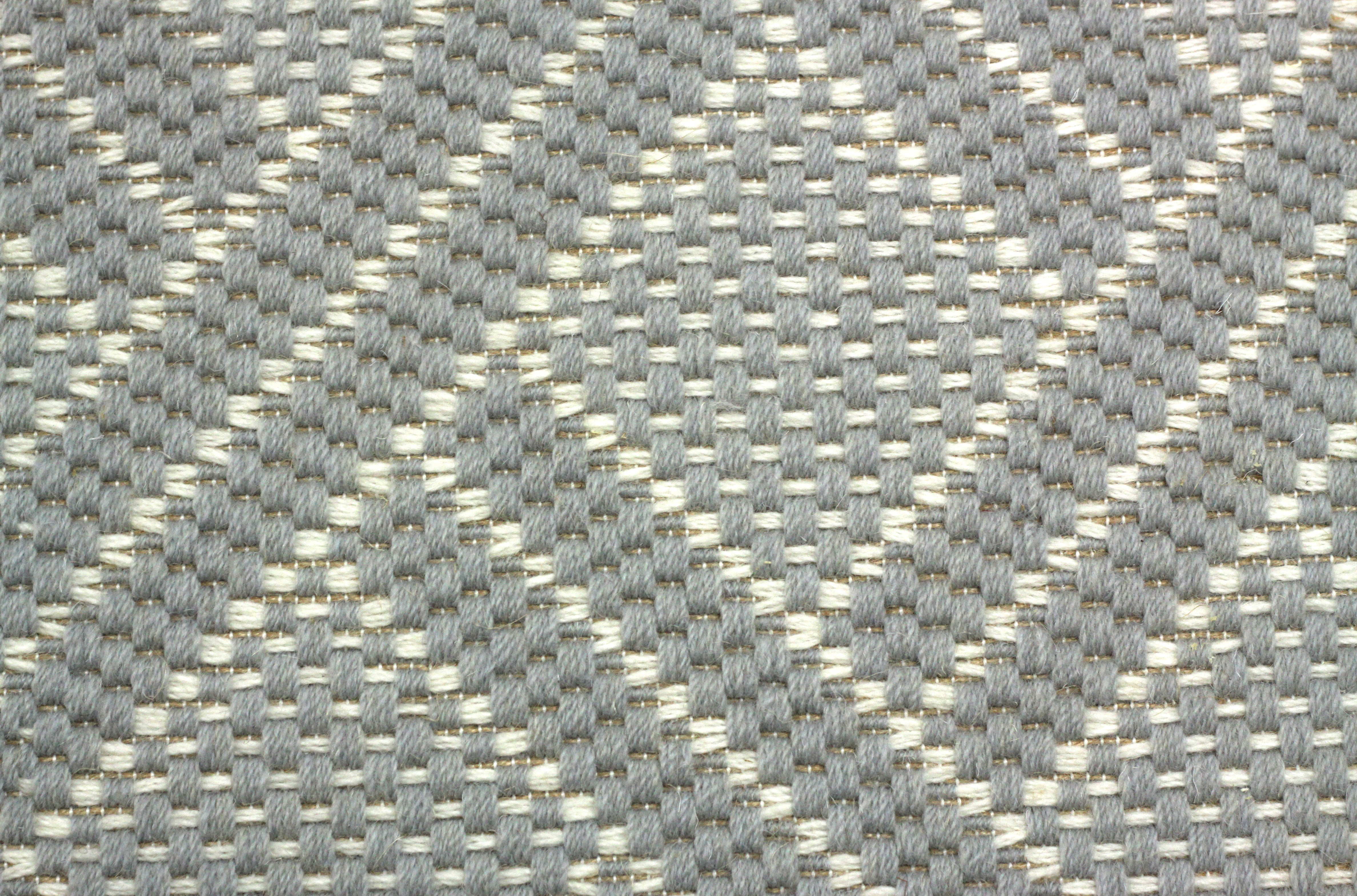 Broadloom carpet in a diamond lattice pattern in light blue and cream. 